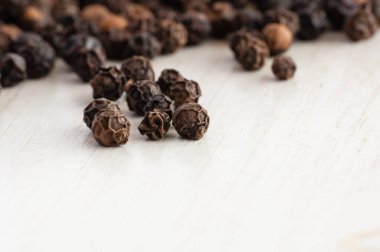 Siyah biber çekirdekleri ve kırmızı kaşık yakın