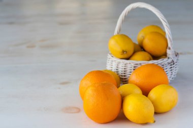 Masanın üzerinde duran taze limon ve portakallar.