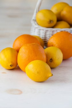 Masanın üzerinde duran taze limon ve portakallar.