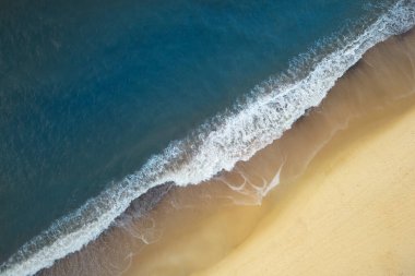 Baltık Denizi kıyı şeridinin hava manzarası, sabah güneş doğarken kumsala vuran dalgalar, kuşun bakış açısı, yukarıdan aşağıya bakış açısı, İHA fotoğrafçılığı.