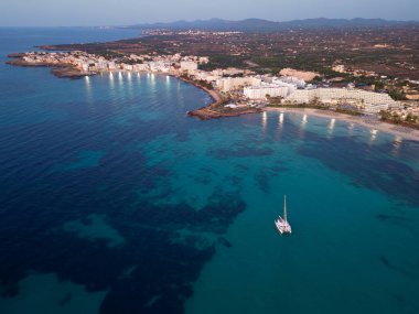 Güneş doğmadan önce yatları, Sa Coma, Malorca, İspanya, Balearic Adaları 'ndaki sahil otellerinin insansız hava aracı görüntüleri.