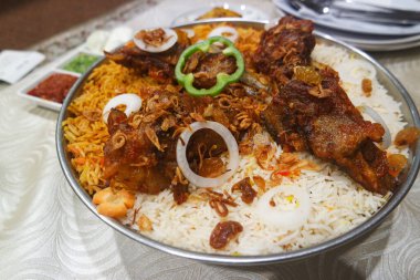 Kabsah Mandy kuzu pirinci. Baharatlı sos ve beyaz ahşap arka planda salata. Mandi pirinci çok lezzetlidir. Baharatlar, aromalar ve kuzu etiyle birlikte..