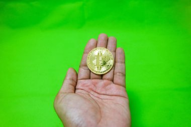 Bitcoin. Yeşil arkaplanda izole edilmiş altın bitcoin