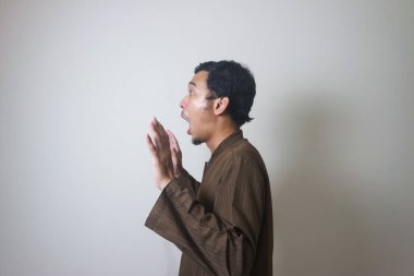 Müslüman Asyalı adam Ramazan kutlamalarında kameraya bakarken şaşırdı. Fotoğraf Ramadhan posteri ve Müslüman içerik medyası için uygun.