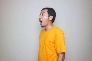 Beyaz arka planda poz veren Asyalı genç bir adamın portresi