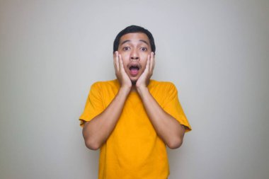 Beyaz arka planda poz veren Asyalı genç bir adamın portresi