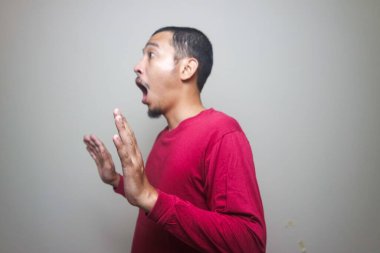 Asyalı adam beyaz arka planda izole edilmiş şok olmuş yüz portresi görünce şaşırdı.