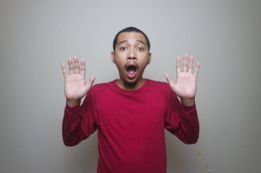 Asyalı adam beyaz arka planda izole edilmiş şok olmuş yüz portresi görünce şaşırdı.