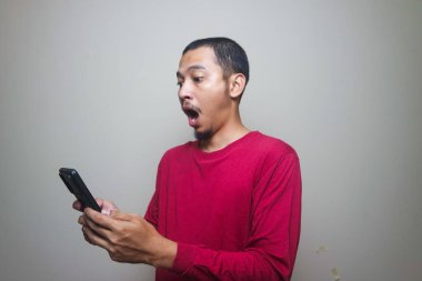 Smart casual asian man using smartphone in studio background