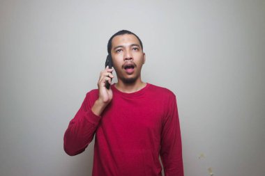 Smart casual asian man using smartphone in studio background