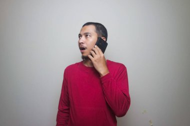 Smart casual asian man using smartphone in studio background