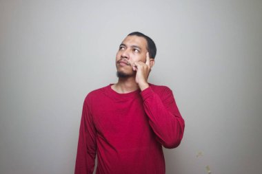 Beyaz arka plan üzerinde izole düşünen genç Asyalı adam.