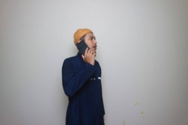 Beyaz arka planda izole edilmiş cep telefonu kullanan Asyalı Müslüman.