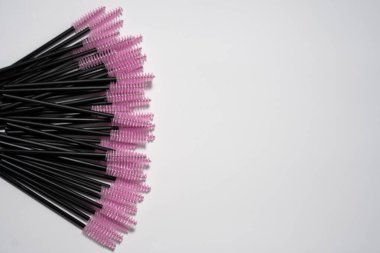 maskara değneği, tek kullanımlık fırça, pembe fırçalar, kozmetik aksesuarlar, makyaj sanatçısı, temiz güzellik, hijyenik aletler, göz makyajı, profesyonel güzellik malzemeleri, beyaz arka plan, kirpik fırça, makyaj bezi, pembe uçlu değnek, kirpik aracı.