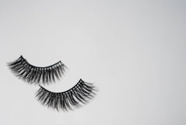 Temiz bir arka planda izole edilmiş bir çift takma kirpiklerin yakın plan görüntüsü, güzellik, makyaj ve kirpik uzatmaları için mükemmel..