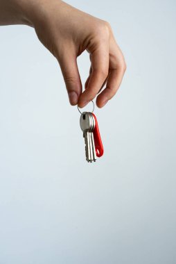 Beyaz Arkaplanda Kırmızı Anahtarlığı olan Üç Anahtarlı Kadın El Tutuşu. Yüksek kalite fotoğraf
