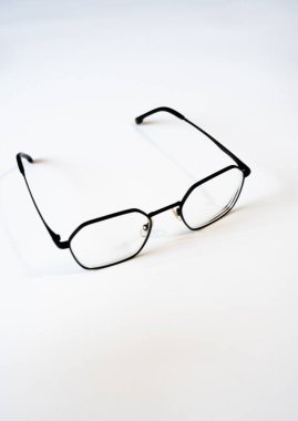 Beyaz yüzeye siyah gözlük takılmış. Optometri, görüş düzeltmesi, sağlık konseptleri, göz tasarımı ve yaşam tarzı fotoğrafları için mükemmel.. 