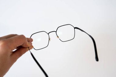 Beyaz arka planda gözlük görünüyor. Görüş, optometri, sağlık, görme düzeltmesi, yaşam tarzı ve tıbbi aksesuarlar kavramı