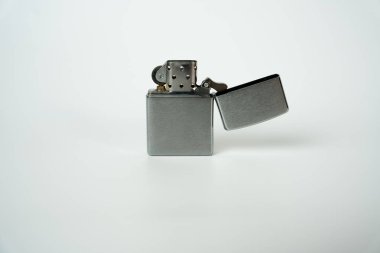 Temiz beyaz arka planda gümüş açık çakmak, ateşin sembolü, ateşleme, sigara içme, bağımlılık ve yaşam tarzı. 