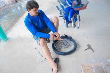 Garajda motosiklet tamir eden bir adam.