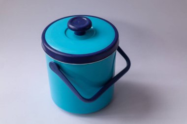 Beyaz arka planda izole edilmiş kapaklı mavi plastik kova. İçecekler için plastik kaplar. Yakın çekim, seçici odaklanma..