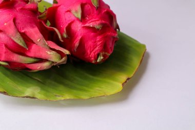 Beyaz arka planda izole edilmiş muz yapraklı ejderha meyvesi. Olgun pitahaya.