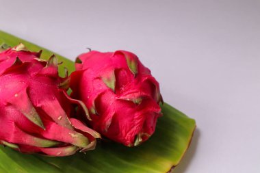 Beyaz arka planda izole edilmiş muz yapraklı ejderha meyvesi. Olgun pitahaya.