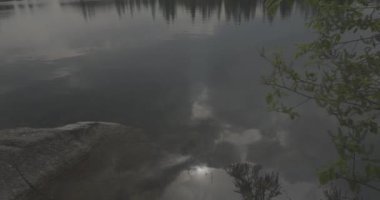 Tatra Dağları 'ndaki göl Strbskie Pleso. Sisli dağlarda, filmler dingin gölleri tasvir eder. Bulutlu gökyüzü kasvetli bir atmosfer yaratıyor. Yansımalar dalgalanır, sahneye ruhani bir cazibe katar. Doğanın güzelliği bulutlar tarafından engellenmeden parlıyor.