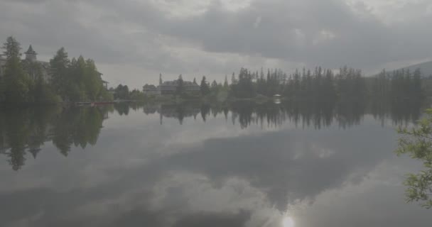 鞑靼山脉的湖泊 Strbskie Pleso 在多雾的山中 电影描绘了宁静的湖泊 阴云密布的天空笼罩着一种忧郁的气氛 反射的涟漪 给这个场景增添了一种飘逸的魅力 大自然的美丽闪烁着 没有被云彩所阻遏 — 图库视频影像