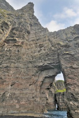      Vgar Adası 'ndaki ünlü SpireTrllkonufingur' un yakınındaki kayalıklar ve mağaralar.                          
