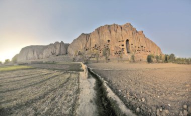 A rock with niches in which Buddha statues once stood in Bamian, Afghanistan clipart