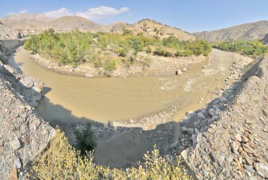 Ghowr Band River flowing through valley in  the Hindu Kush Mountains in Afghanistan clipart