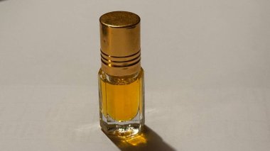 İçi altın kokulu sıvıyla dolu küçük cam şişe..