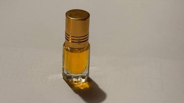 İçi altın kokulu sıvıyla dolu küçük cam şişe..