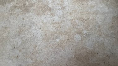 Ele geçirilen, yaşlanmış, desenli bir yüzeye ait tam kare ve yakın plan bir görüntü, soluk bej bir ton ve dağınık saç çizgisi çatlakları, yıpranmış ancak ayrıntılı bir görünüm sağlıyor..