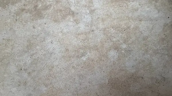 Ele geçirilen, yaşlanmış, desenli bir yüzeye ait tam kare ve yakın plan bir görüntü, soluk bej bir ton ve dağınık saç çizgisi çatlakları, yıpranmış ancak ayrıntılı bir görünüm sağlıyor..