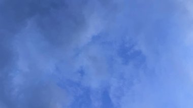 Düşük açılı bir çekim, sağanak yağış bulutlarının hakim olduğu bulutlu bir gökyüzünü, yaklaşan bir fırtınaya işaret ediyor. Karamsar atmosfer.