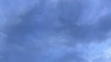 Karamsar mavi gökyüzünün tam çerçeve görüntüsü koyu, bulutlu bir katman ile dolu, yaklaşan fırtınayı işaret eden mavi renkler boyunca değişen.