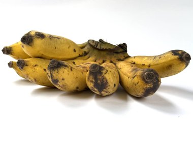 Yüksek çözünürlüklü bir grup olgun sarı muzun koyu lekeler ve aşınmalar gösteren fotoğrafı. Stüdyo çekiminde beyaz bir arka planda izole edilmiş..