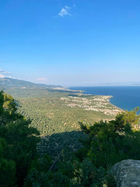 Doğa manzarası gökyüzü yeşil ağaç mavi gökyüzü okyanus ve mavi güzel dağ suyu tepesini görüyor