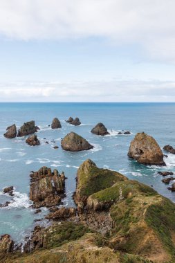 Caitlans, Yeni Zelanda 'daki Nugget Point' te okyanustan çıkan kayaların fotoğrafı.