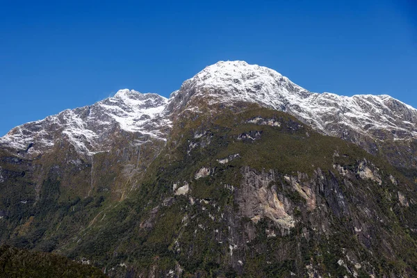 Een Besneeuwde Bergketen Met Groen Plantenleven Diverse Watervallen Dit Bereik — Stockfoto