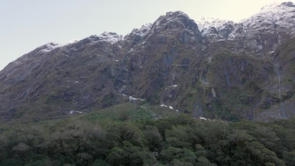 ニュージーランドのミルフォード サウンドに向かう途中の滝がたくさんある丘 丘の上には雪があり 緑豊かな生活もたくさんあります — ストック動画