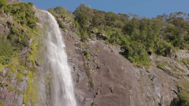 ニュージーランドのミルフォード サウンドで落下した滝の真ん中 ショットはそれが落ちるように水を追跡します — ストック動画
