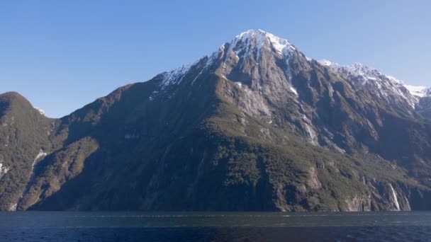 ニュージーランドのミルフォード サウンズで ミドルピークのパンニングショット ショットは 水の上のボートから撮影されます — ストック動画