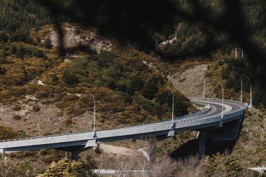 A photo taken in Kenepuru Wellington. It's of a new expressway called transmission gulley. The road is steep, curved and goes around a hill. clipart