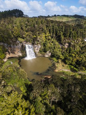 İnsansız hava aracıyla çekilen bir görüntü. Auckland Yeni Zelanda 'da yer alan Hunua Şelalesi adında bir şelale içerir. İnsansız hava aracı şelalenin tam üstünde, yana bakıyor..