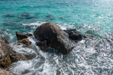 Güzel manzaralı deniz manzaralı deniz suyu kayalık sahil sahilinde, adaya su sıçratan dalgalar, gökyüzü kayası uçurum kıyısı gelgitleri seyahat ve turizm için arka plan, yüksek enerjili turkuaz pasifik.