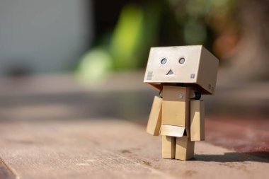 Küçük tahta oyuncak robot danbo yalnız başına yalnız başına üzgün karakter, ahşap zemin çizgi film kutusu anime mutlu sanat konsepti yaz, kahverengi oyuncak bebek ruh hali yalnızlık duygusu renkli tatil