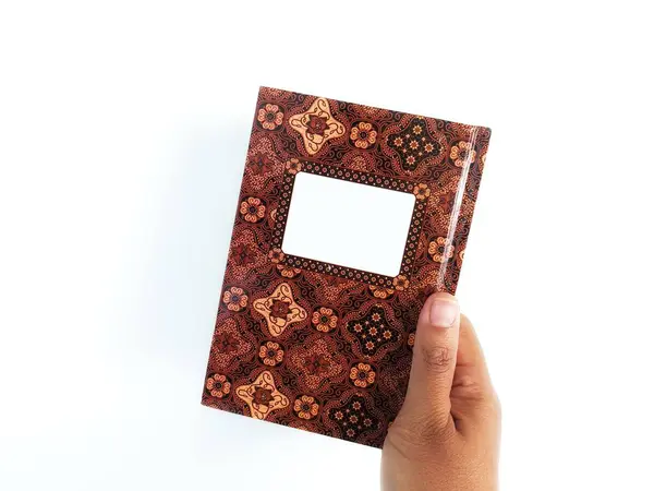 hand holding batik cover book,isolated on white background